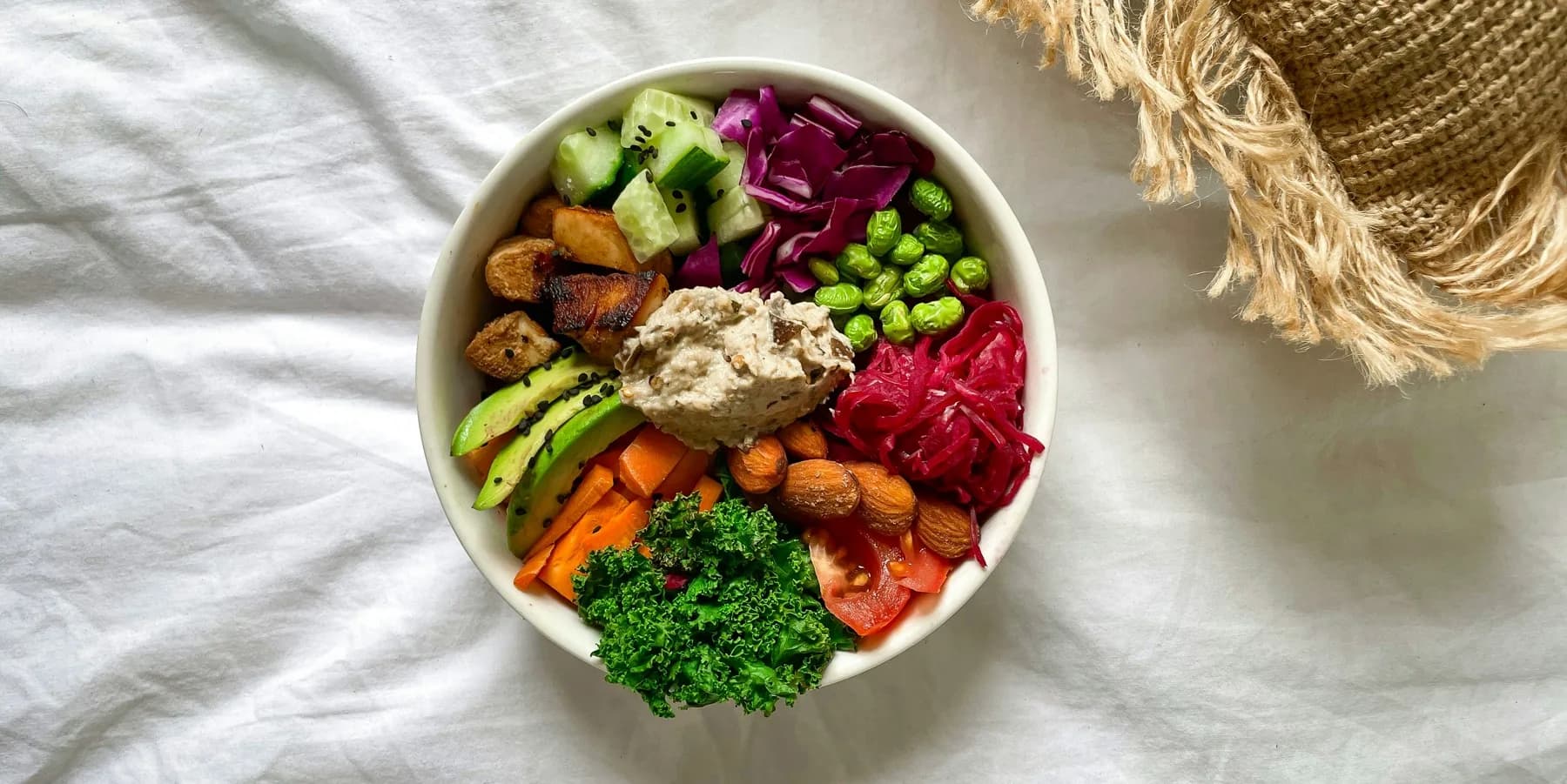 Šarena bowl salata sa avokadom, povrćem, bademima i humusom.