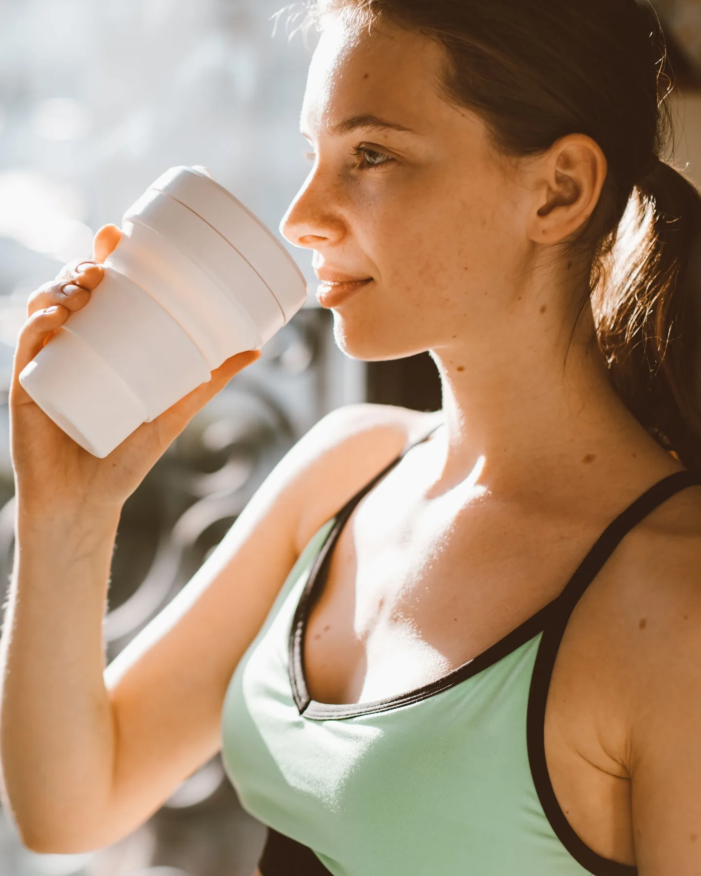 Fitnes devojka pije proteinsko piće